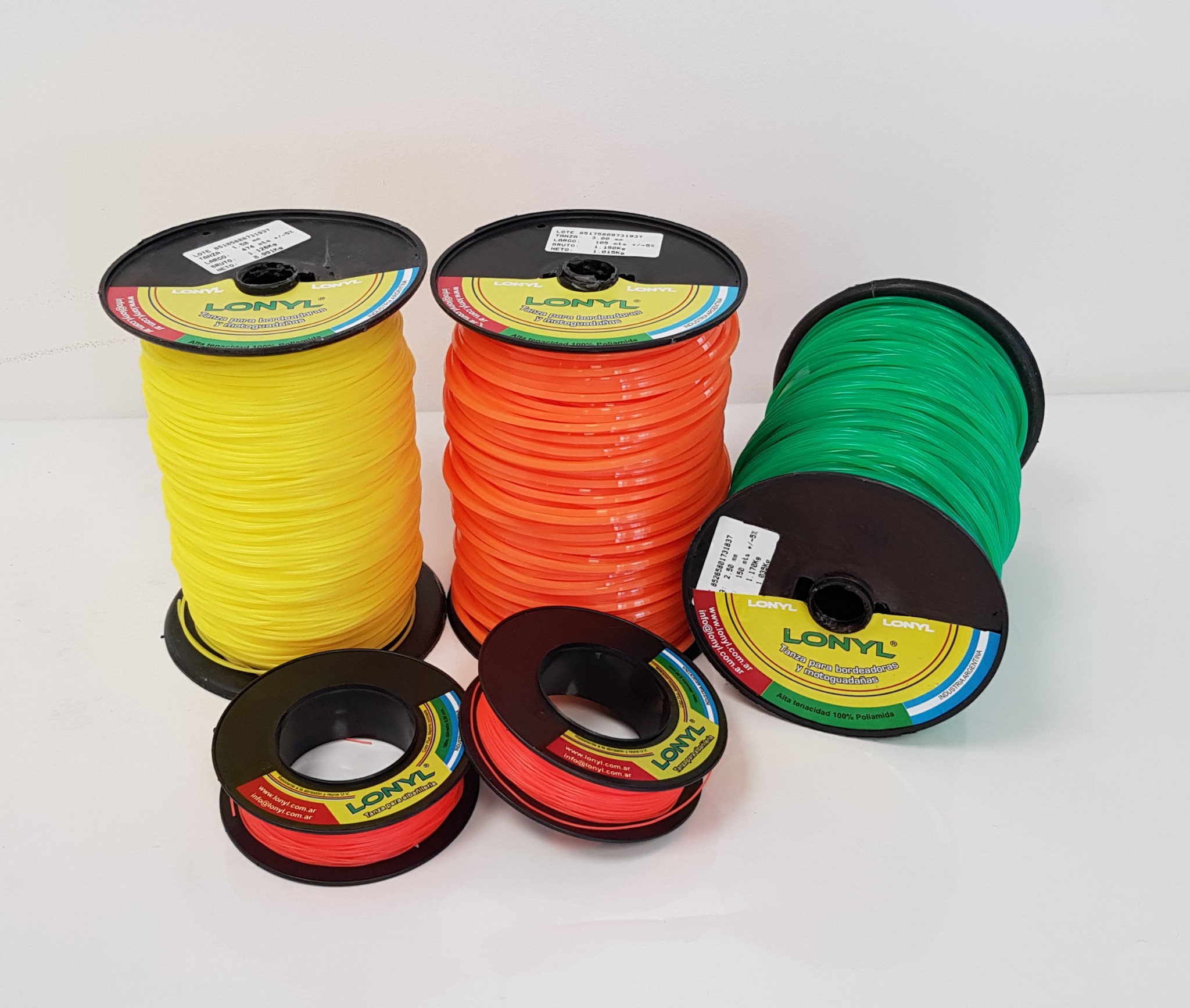 Bobinas de tanza Lonyl en colores amarillo, naranja, verde y rojo